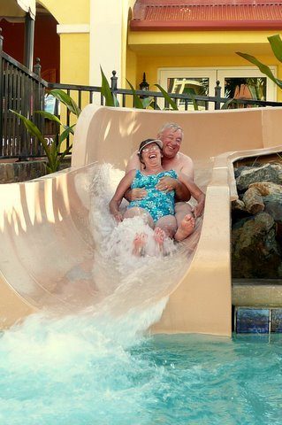 A couple coming down a resort water slide together