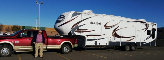 A red pickup truck hitched to a fifth-wheel travel trailer
