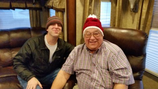 Two men seated indoors in knitted caps