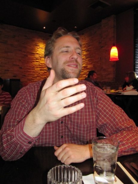 A bearded man at a restaurant table