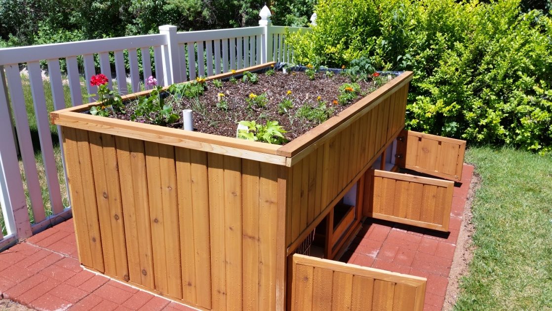 The garden bed from the corner with its plinth doors open, showing the storage underneath