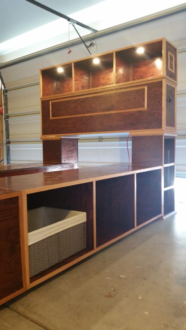 The finished headboard and shelf unit with a lit recess across the top