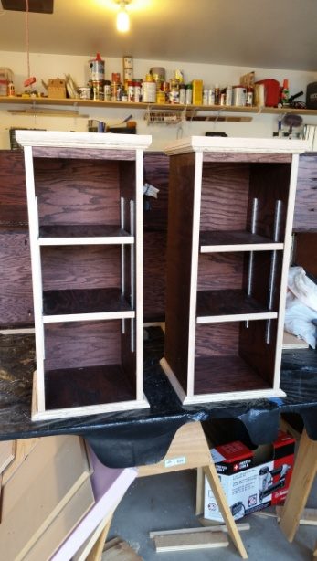 Two tall white open shelving carcasses standing side by side, unfinished