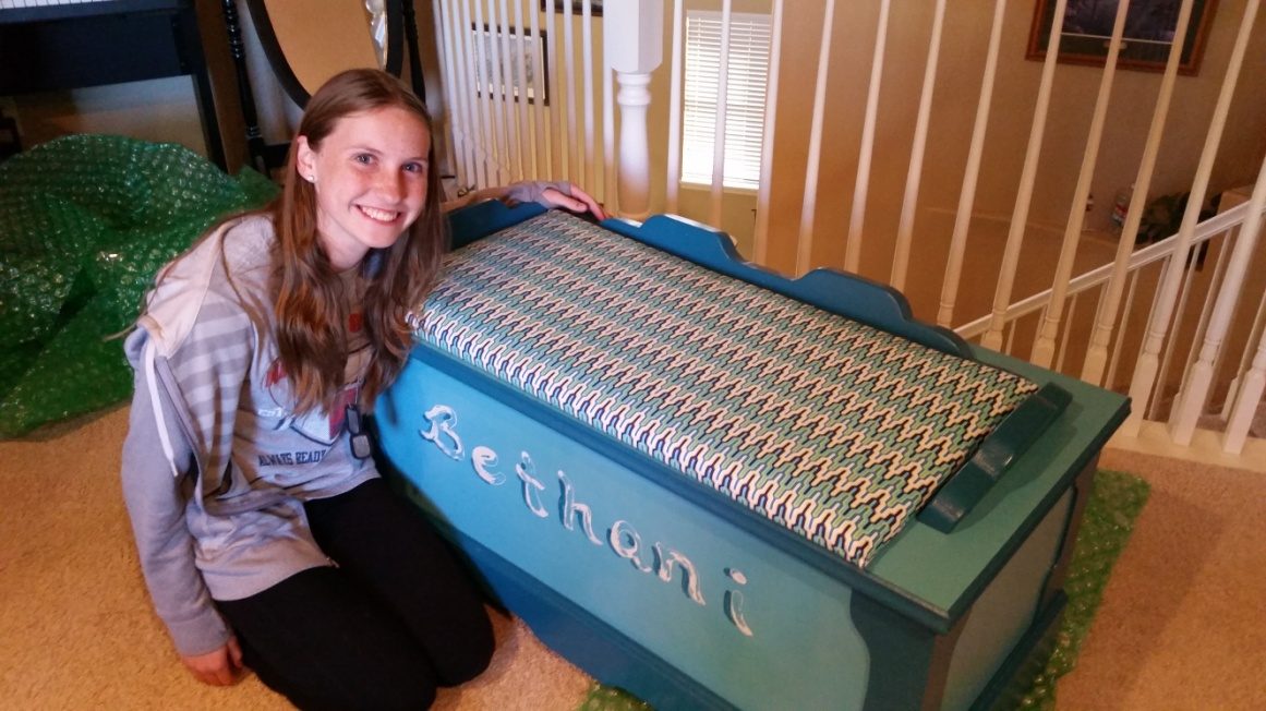 The teal hope chest with the name BETHANI carved through the lid