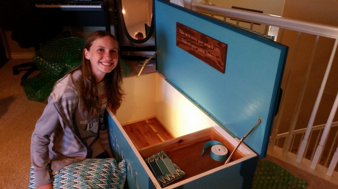 An open teal hope chest, the inlaid lid reading: Make me to know your ways O LORD — Psalms 25:4